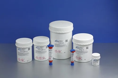 White cans with conductive Elecolit adhesive on a blue-silver background