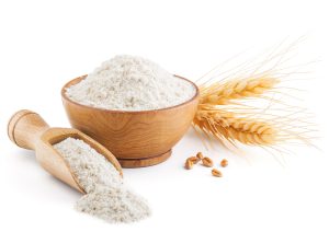 UV decontamination solutions for bakeries and food processing Wooden scoop and bowl filled with flour, with wheat ears and corn kernels nearby, illustrating UV decontamination of air, surfaces and equipment in bakery and food processing.